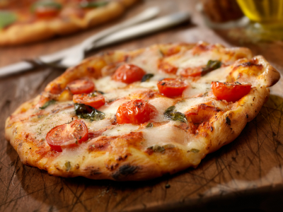 A margherita pizza with mozzarella, baby tomatoes and oregano.